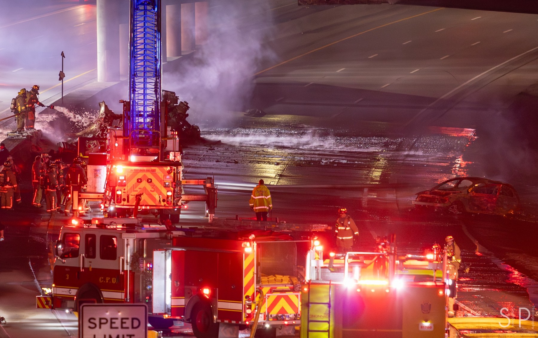 Fire crews and apparatus working at a highway emergency scene at night