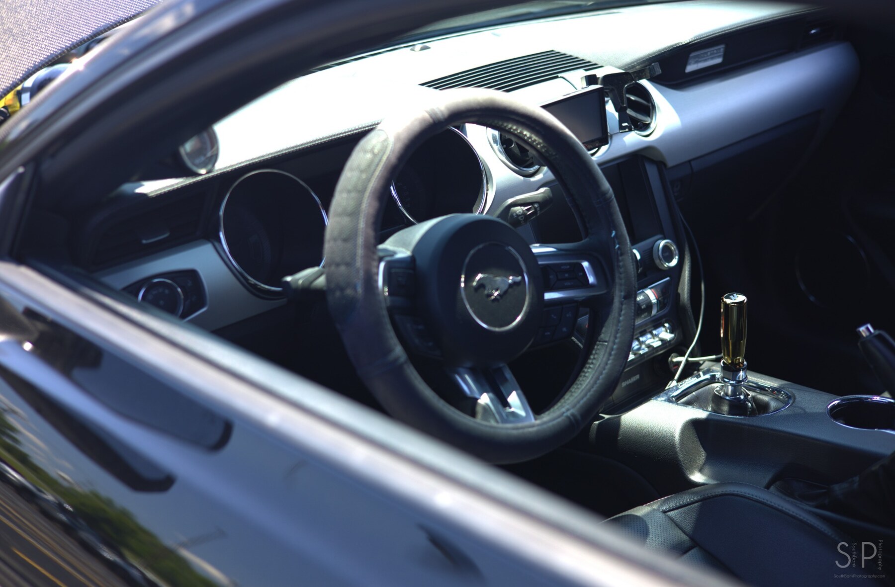 Steering wheel, shifter, and dashboard inside a modern Ford Mustang