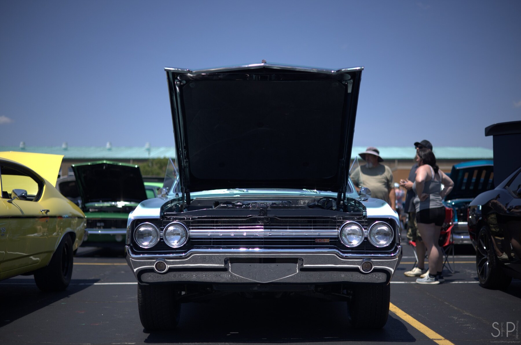 Turquoise 1965 Oldsmobile 442 photographed head-on with its hood open