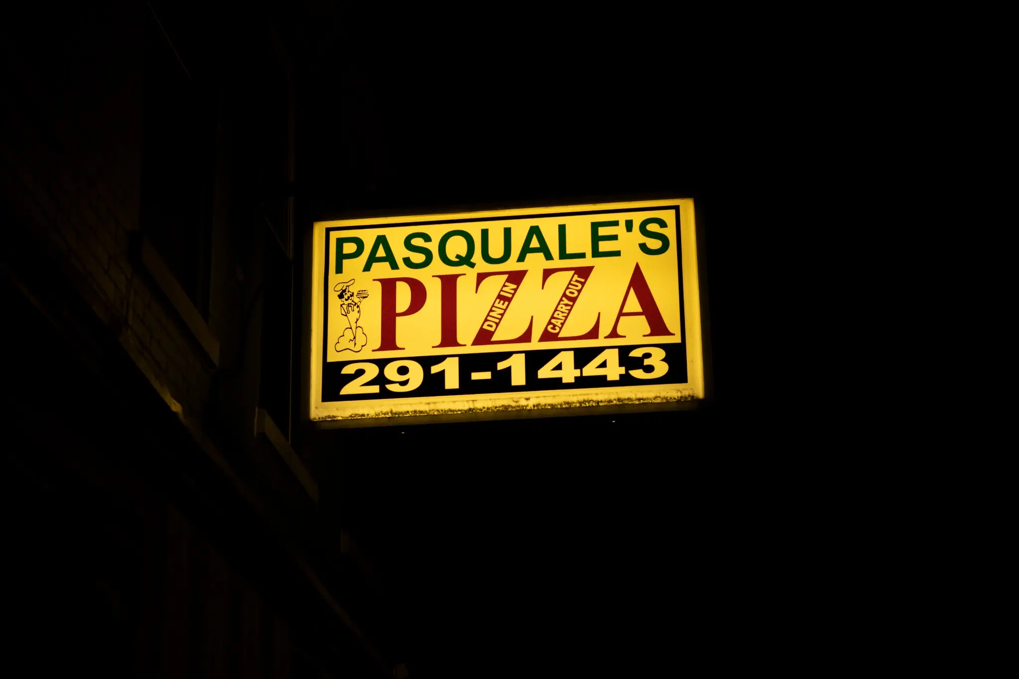 Pasquale's Pizza sign glowing against the night